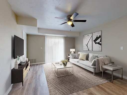 A living room with a grey couch, a coffee table, and a television.