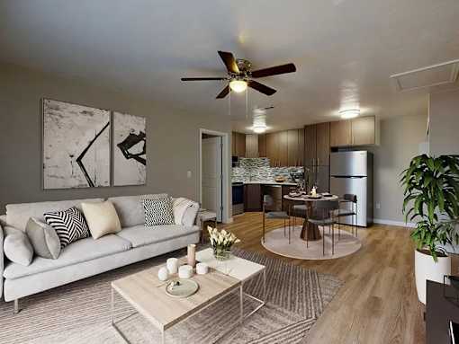 A living room with a couch, coffee table, and a ceiling fan.