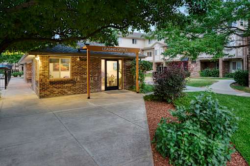 A brick building with a glass door and a sign that says "Leasing Office".