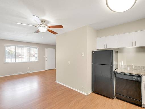A kitchen area with a black refrigerator and an oven.