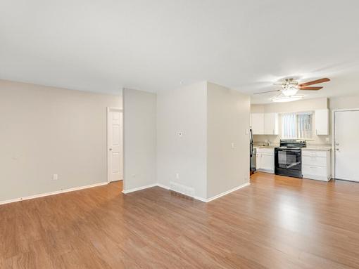A room with a kitchen area in the background.