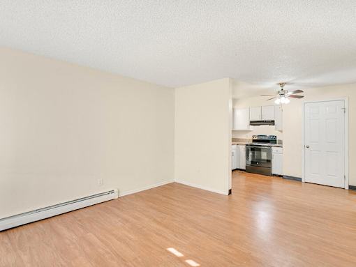 A room with a wood floor and a ceiling fan.