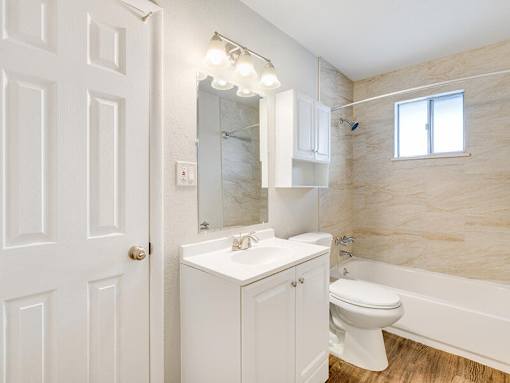 A white bathroom with a toilet, sink, and bathtub.