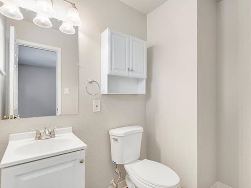A white toilet sits next to a sink in a small bathroom.