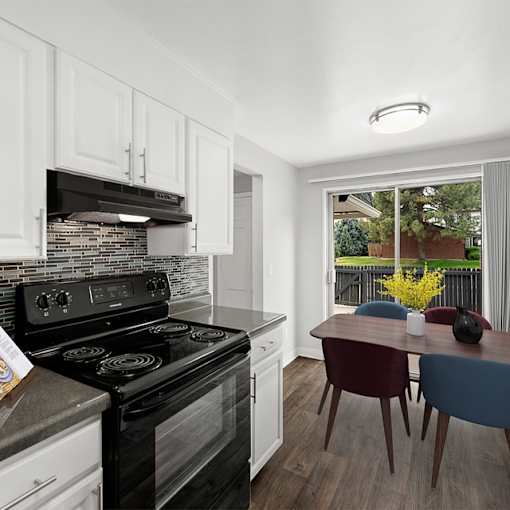 A modern kitchen with a black stove top oven and white cabinets.