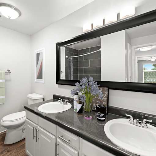 A bathroom with a black countertop and a white toilet.