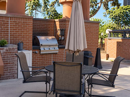 A patio with a table, chairs, and an umbrella.