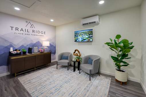 A waiting room with chairs and a television.