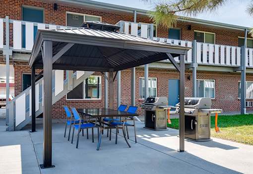 A patio with a table and chairs under a canopy.