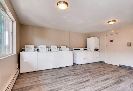 A room with white appliances and a grey floor.