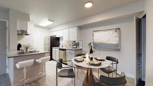A modern kitchen with a dining table set for two.