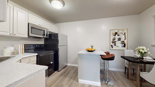 A kitchen with black appliances and white cabinets.