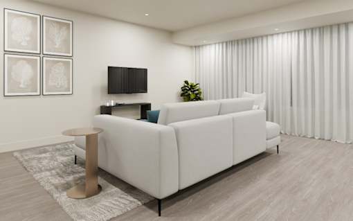 A white sofa with a wooden stool in front of it in a room.