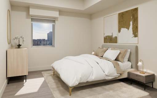 A bedroom with a large bed and a window overlooking a cityscape.