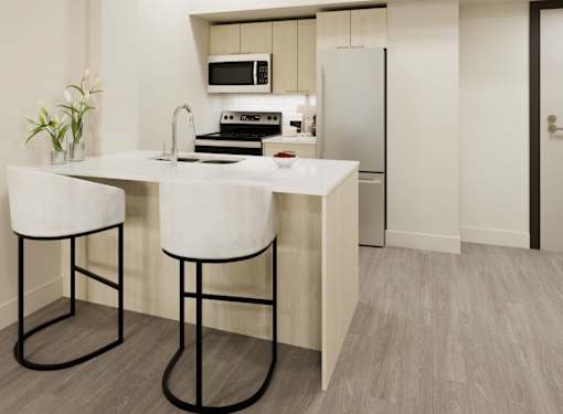 A kitchen with a white countertop and bar stools.