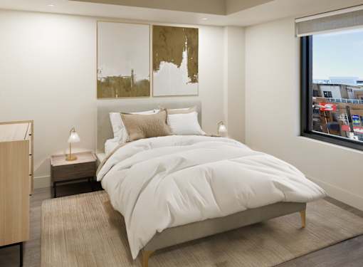 A bedroom with a large bed and a window overlooking a cityscape.