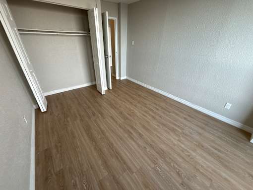 A room with wooden flooring and white walls.