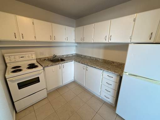 A kitchen with white appliances and cabinets.