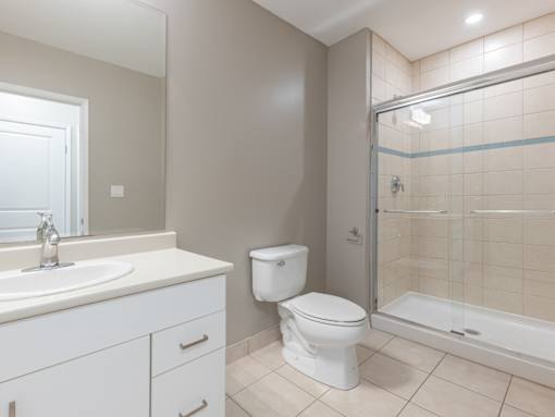 A white toilet sits next to a sink in a bathroom.