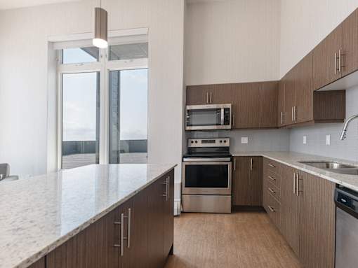 A modern kitchen with wooden cabinets and stainless steel appliances.