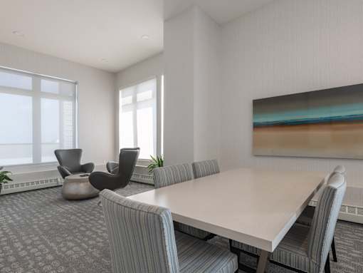 A modern dining room with a large table and chairs.