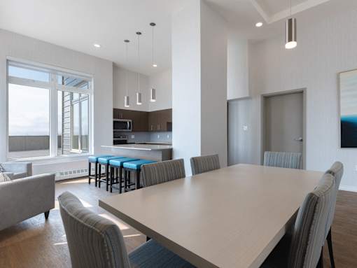 A modern dining room with a large table and chairs.