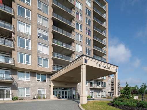 The entrance to The Charles apartment building with a blue sky in the background.