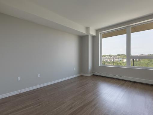 A room with a large window and wooden flooring.