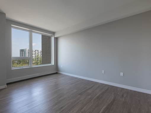 A room with a large window and wooden flooring.
