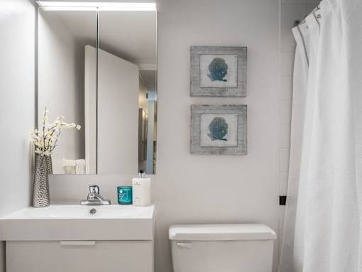 A white bathroom with a white sink and toilet.
