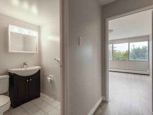 A bathroom with a sink, toilet, and mirror.