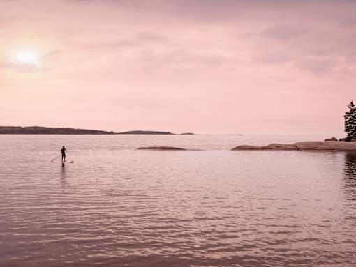 A person is standing in the water with a paddle.