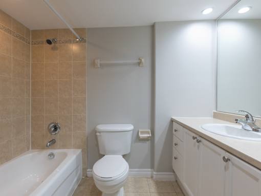 A white toilet sits next to a sink in a bathroom.