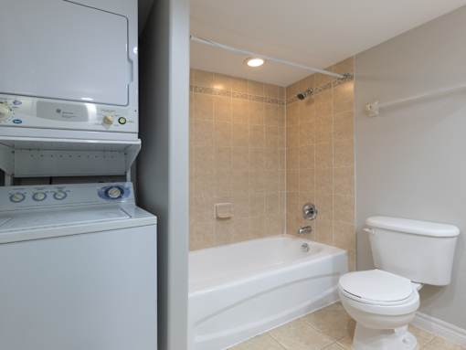 A white toilet sits next to a bathtub in a bathroom.