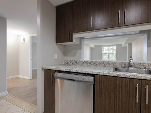 A kitchen with brown cabinets and a stainless steel dishwasher.