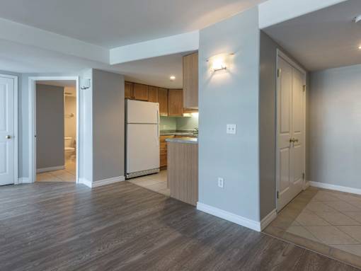A kitchen with a white refrigerator and wooden cabinets.