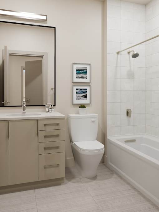 A white toilet sits next to a white bathtub in a bathroom.