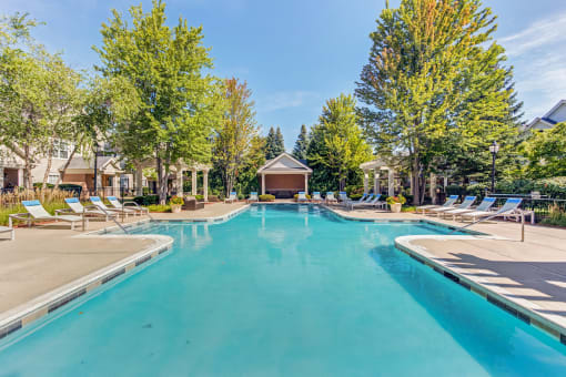 Aurora, IL Townhomes - The Apartments At Kirkland Crossing - Pool With Lounge Chairs And Trees Surrounding.