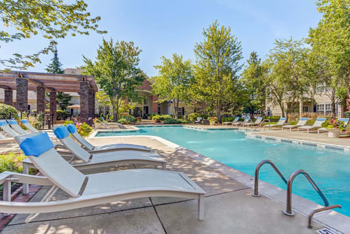 Townhomes in Aurora, IL for Rent - Kirkland Crossing - Pool with Sun Lounge Chairs, Trees, and Potted Plants
