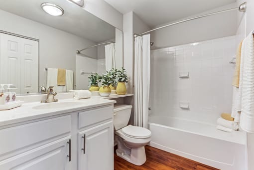 Townhomes in Aurora, IL - Kirkland Crossing - Bathroom with a Bathtub, Wood-Style Floors, and Quartz Sink