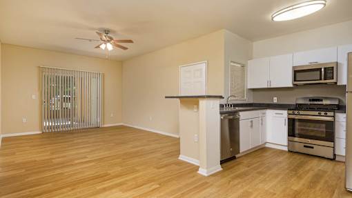 A spacious kitchen with white cabinets and stainless steel appliances.