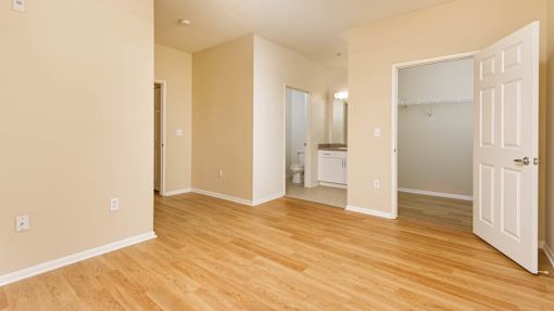 A room with a white door and a mirror on the wall.
