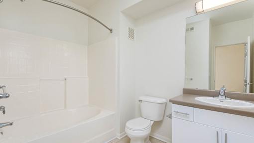 A white bathroom with a toilet, sink, and bathtub.