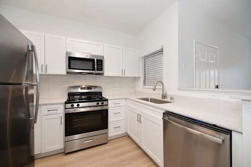 A kitchen with white cabinets and stainless steel appliances.