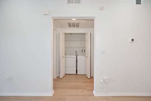 A white laundry room with a washer and dryer.