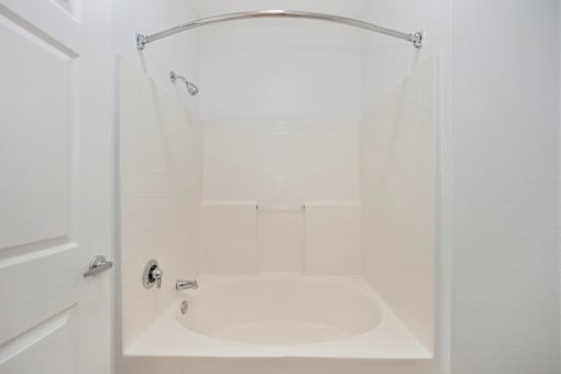 A white bathroom with a tub and shower.