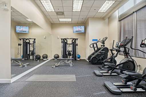 A gym with treadmills, exercise bikes, and weightlifting equipment.