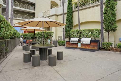 A patio with a table, chairs, and umbrella.