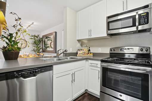 A modern kitchen with stainless steel appliances and white cabinets.