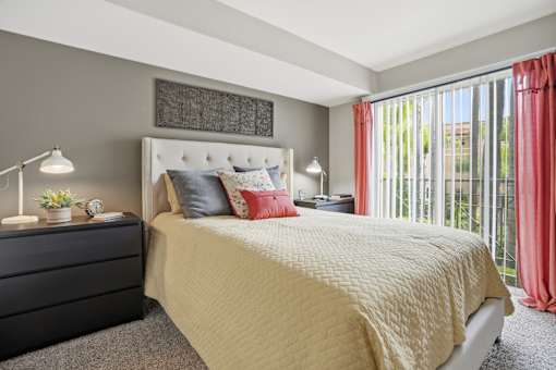 A bedroom with a large bed and a black dresser.